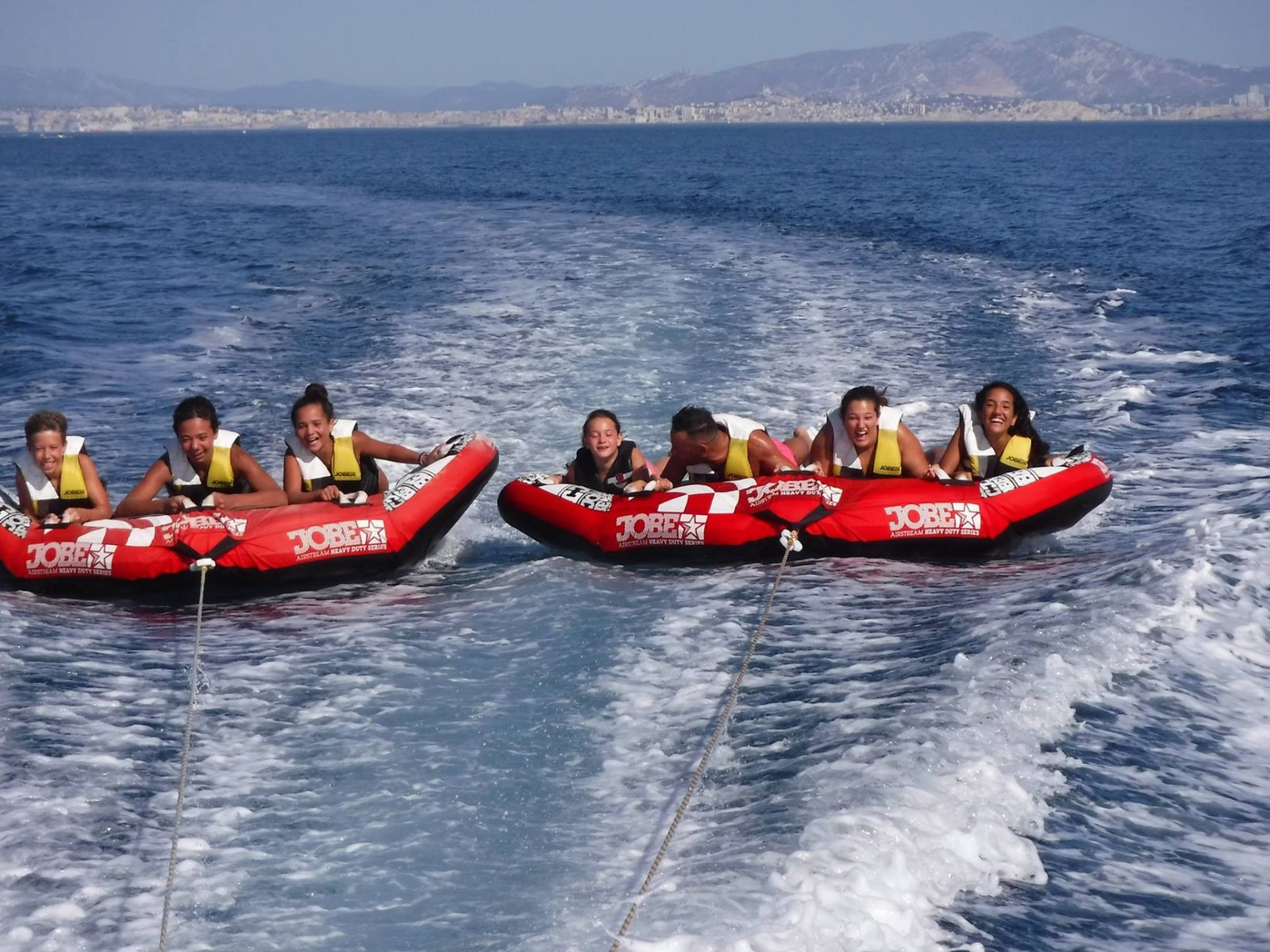 Groupe d'amis sur une bouée tractée banana en Méditerranée